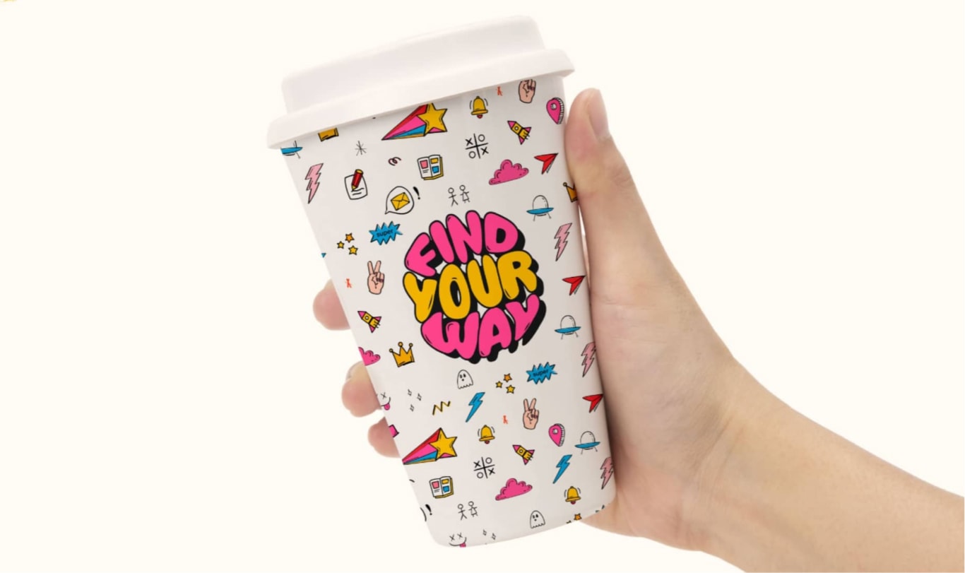 Gobelet Find Your Way tenu en main, couvert d'illustrations